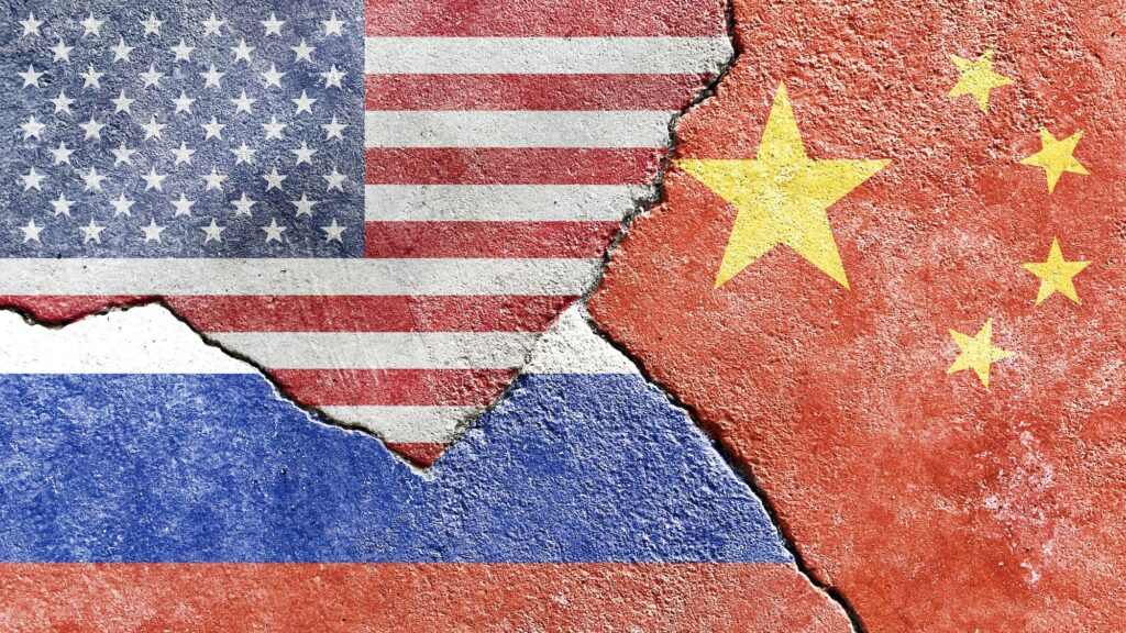 American Chinese and Russian flag on a cracked wall politics conflict war concept