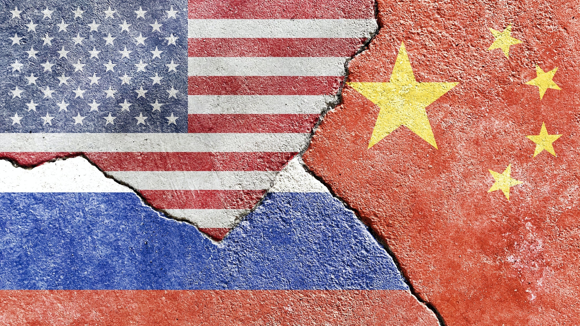 American, Chinese, and Russian flag on a cracked wall- politics, conflict, war concept