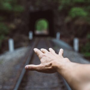 A man’s hand on the train tracks.