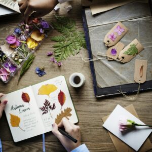 Hands Writing Detail of Dried Flowers Collection in Notebook Han