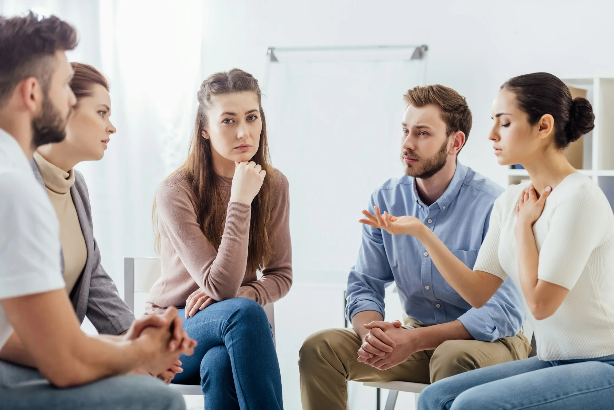 people sitting on chairs and having discussion during support group meeting